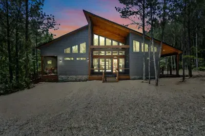 Exterior: Modern cabin with expansive windows nestled in nature, perfect for sunset gatherings!