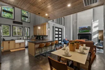 Open-concept living and dining area with soaring ceilings and stylish cabin décor