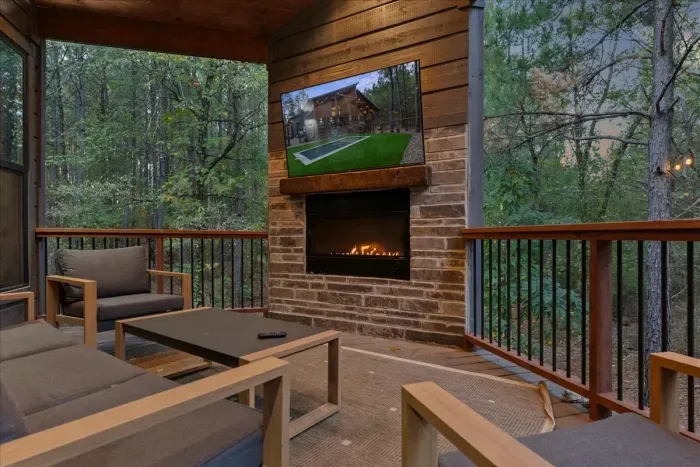 Covered patio with a cozy fireplace and comfortable seating for enjoying the outdoors in any season.