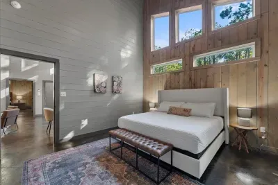 Spacious, sun-lit bedroom retreat featuring serene forest views