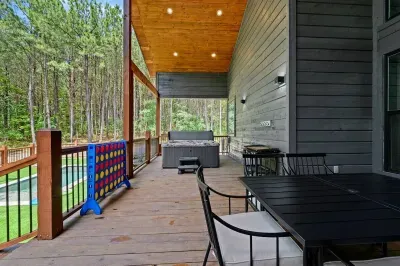 Spacious covered deck with railing and views of the surrounding woods