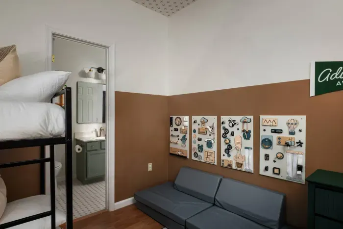 Adventure awaits! This playful bunk room includes interactive busy boards for little explorers — ideal for keeping curious toddlers engaged while you relax.