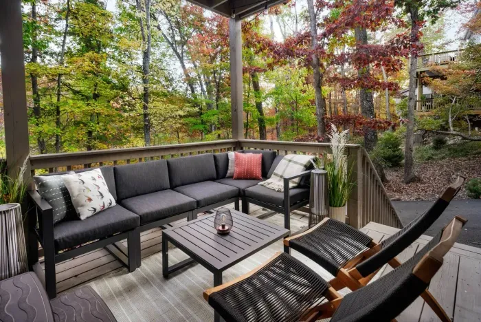 Unwind on the covered deck surrounded by forest views. This cozy lounge is perfect for morning coffee, afternoon reading, or sunset conversations under the trees.