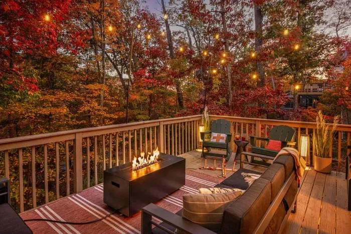 Cozy evening on a softly lit deck with a glowing fire and relaxed seating ✨