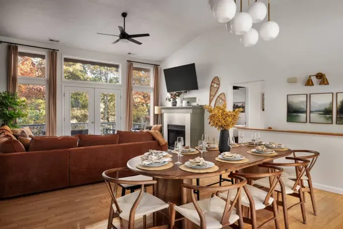 This spacious great room brings everyone together — from the inviting sectional by the fireplace to the dining table with seating for 10-12 guests. Enjoy meals surrounded by warm wood accents, forest views, and abundant natural light.