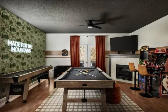 Unwind in the ultimate game room featuring a full-size (8’) pool table, shuffleboard, dartboard, and arcade machines. Cozy up by the fireplace or watch a movie on the large flat-screen TV — a perfect hangout space for all ages.
