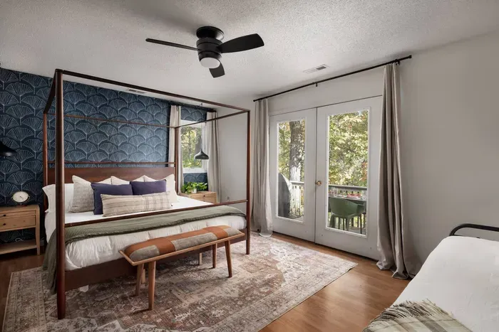 Relax in the inviting primary bedroom with a luxurious king-size bed, private balcony access, and an ensuite bathroom. Wake up to beautiful forest views just beyond the French doors.