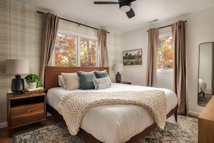 Settle into a warm and inviting retreat—complete with a plush king bed, charming plaid wallpaper, a full dresser, and a 50” Roku TV for unwinding in style.