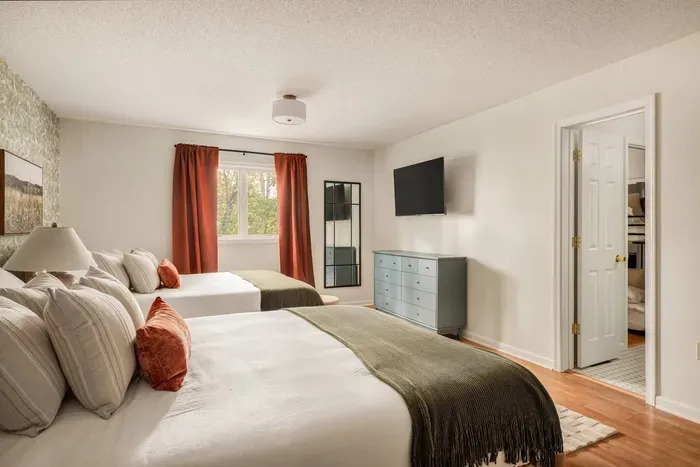This spacious double-queen room features a full dresser, a 50” Roku TV, and calming woodland views.