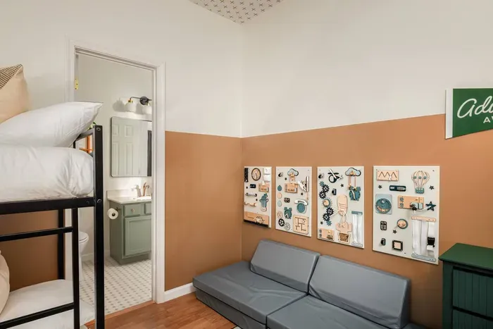 This playful bunk room includes interactive busy boards for little explorers — ideal for keeping curious toddlers engaged while you relax.