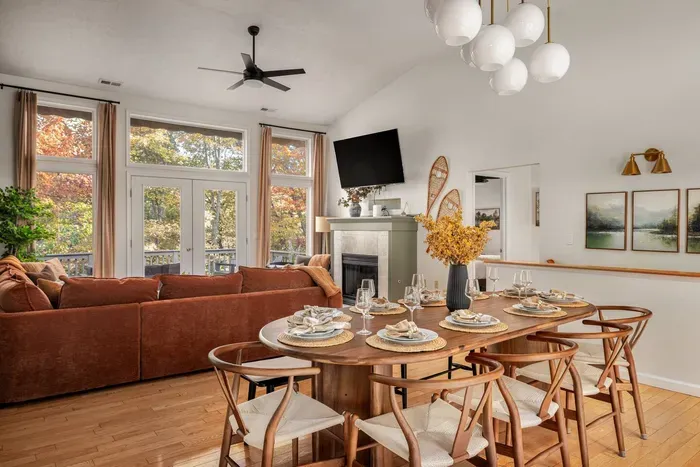 This spacious great room brings everyone together — from the inviting sectional by the fireplace to the dining table with seating for 10-12 guests. Enjoy meals surrounded by warm wood accents, forest views, and abundant natural light.
