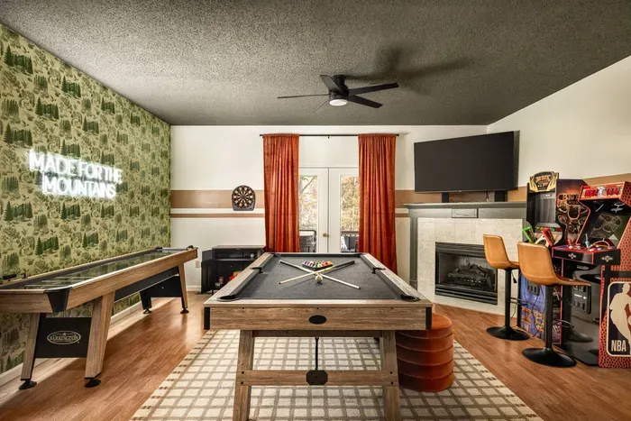 Unwind in the ultimate game room featuring a full-size (8’) pool table, shuffleboard, dartboard, and arcade machines. Cozy up by the fireplace or watch a movie on the large flat-screen TV — a perfect hangout space for all ages.