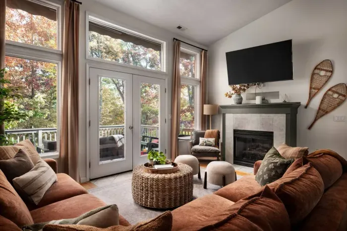 Cozy up by the fire and enjoy movie nights or morning coffee with loved ones — this inviting living room blends warmth, comfort, and beautiful forest views for unforgettable family moments.