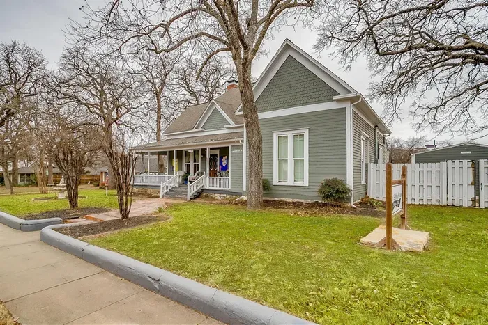 Spacious front yard with mature trees, offering a peaceful and picturesque setting