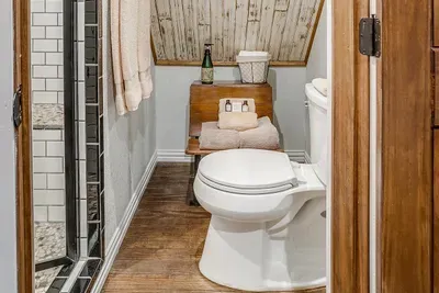 Private bathroom featuring modern fixtures, a walk-in shower, and warm wood details
