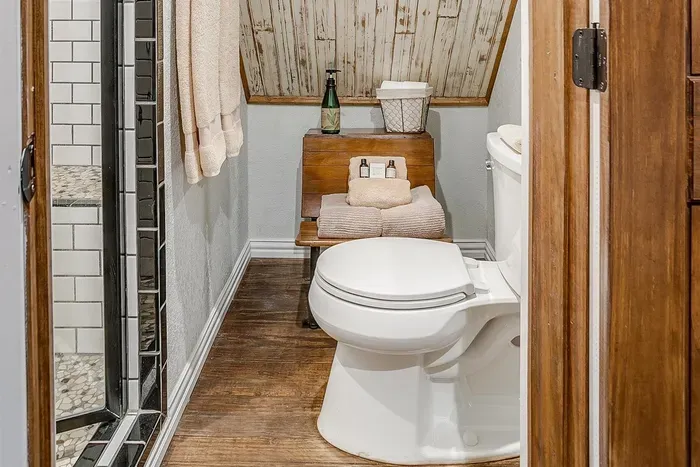 Private bathroom featuring modern fixtures, a walk-in shower, and warm wood details