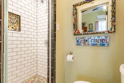 This luxurious bathroom features a beautifully designed walk-in shower with Austin-style mosaic tiles, combining modern style with a touch of elegance. It’s the perfect space to unwind and refresh after a day of exploring.