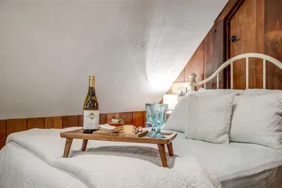 Relax in this charming attic loft with thoughtful details, including a cozy bed and seating area