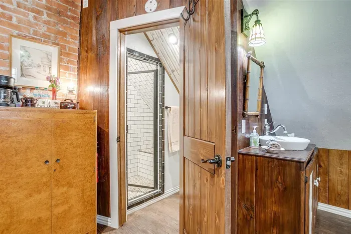 Spacious ensuite bathroom with a walk-in shower and wood-paneled accents for added charm