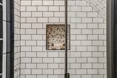 Beautiful mosaic tile accents in the walk-in shower, adding a unique touch to the ensuite bathroom