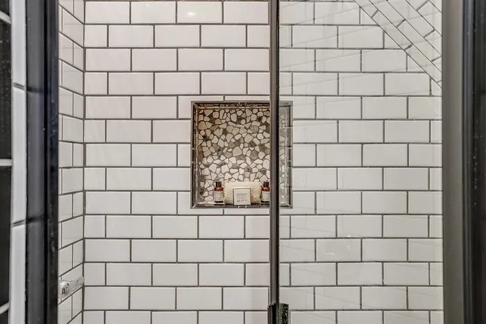 Beautiful mosaic tile accents in the walk-in shower, adding a unique touch to the ensuite bathroom