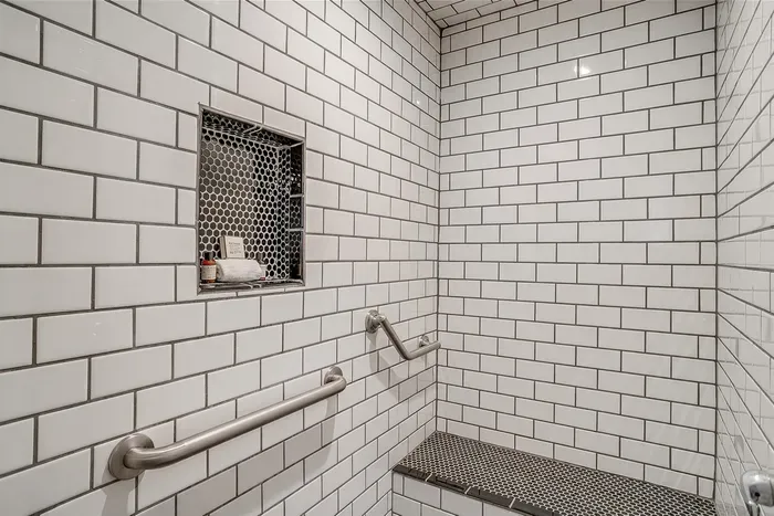 Modern, ADA-compliant walk-in shower with a built-in bench and stylish tile work for a spa-like experience