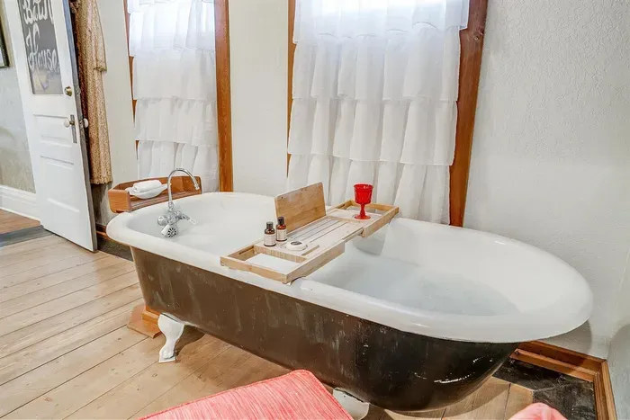 Relax in a private ensuite bathroom featuring an original clawfoot bathtub for a luxurious soak after a long day