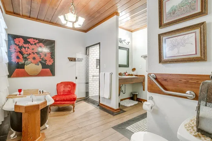 Expansive ensuite bathroom featuring a clawfoot tub and an ADA-compliant walk-in shower for ultimate relaxation