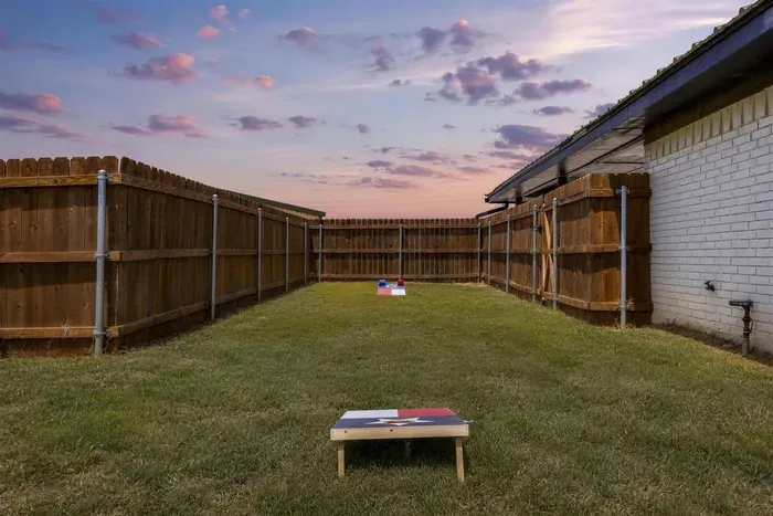 Texas flag cornhole boards and open lawn for the kids to run.