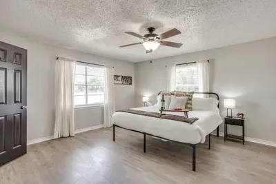 Primary bedroom with a king bed smart tv, and ensuite bathroom