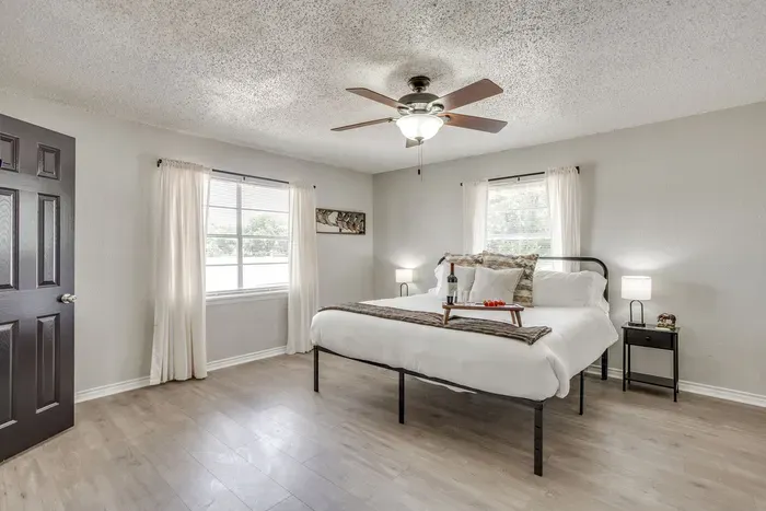 Primary bedroom with a king bed smart tv, and ensuite bathroom