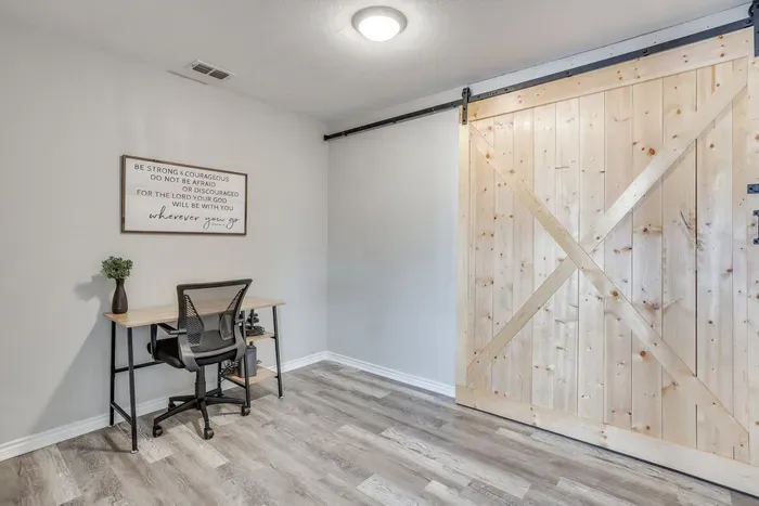 Dedicated office with a desk, a chair in its own room.
