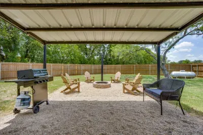 Covered pavilion with a gas grill and propane provided, opening right onto the fire pit.