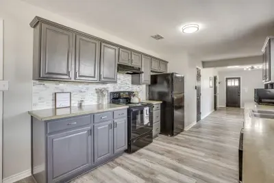 Fully stocked kitchen with a full electric range, dishwasher, microwave, and refrigerator.