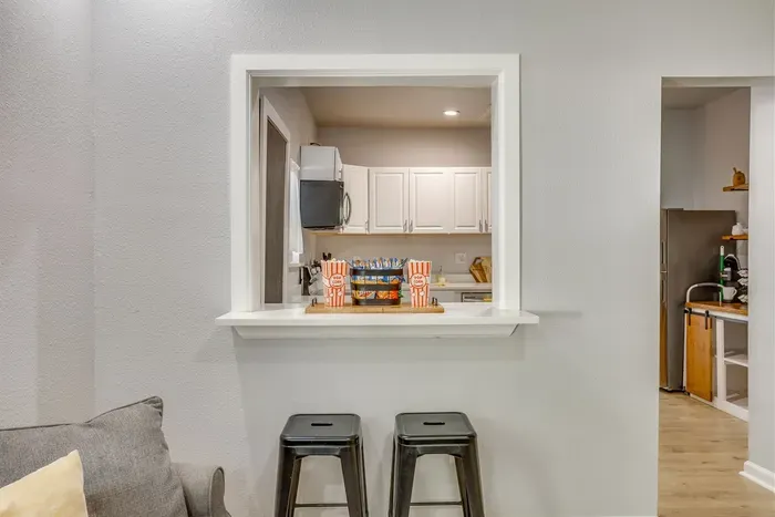Open kitchen pass-through with bar seating — perfect for casual meals, morning coffee, or keeping the conversation going while someone cooks.