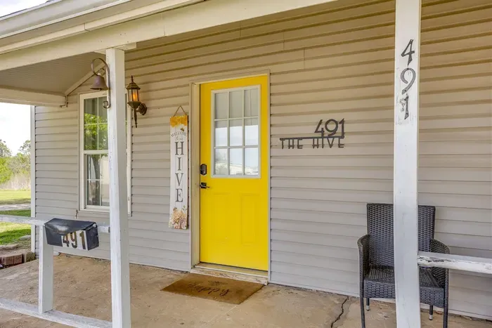 The Hive's bright yellow front door at 491 — bold, cheerful, and impossible to miss. You'll know you're in the right place.