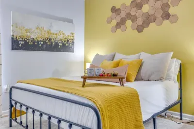 King bed in the master bedroom dressed in yellow and white linens, honeycomb wall décor, and bee-themed accents — cozy, intentional, and one of a kind.