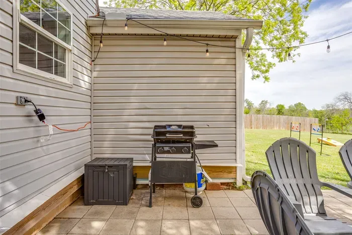 Back patio with gas grill, Adirondack chairs, and string lights — everything you need for a backyard cookout at The Hive.