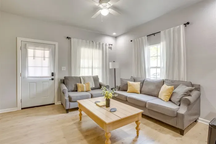 Open and airy living room with sectional sofa, hardwood floors, and plenty of natural light — a comfortable space for the whole group to unwind.