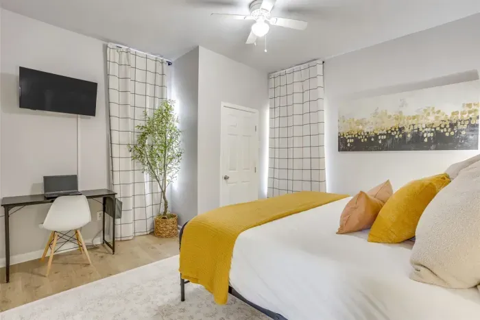 Master bedroom with king bed, Smart TV, dedicated workstation, and full bee-themed décor — comfortable for both work trips and getaways.