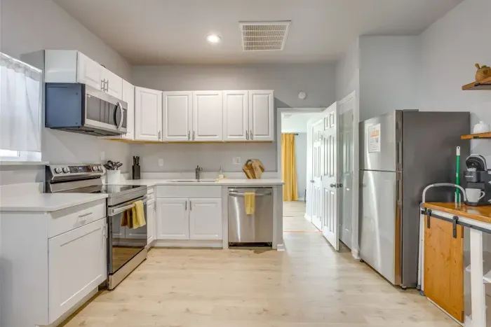 Fully equipped kitchen with stainless steel appliances, white cabinets, and everything your group needs to cook and eat together.