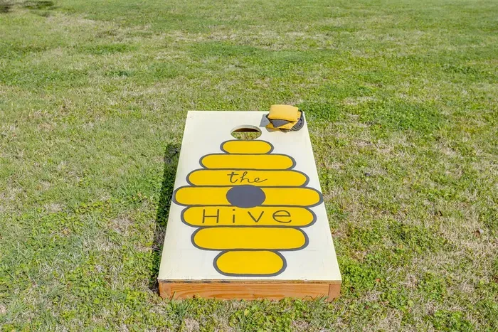 Custom Hive cornhole board — because even the yard games match the theme. Grab a partner and see who reigns supreme.