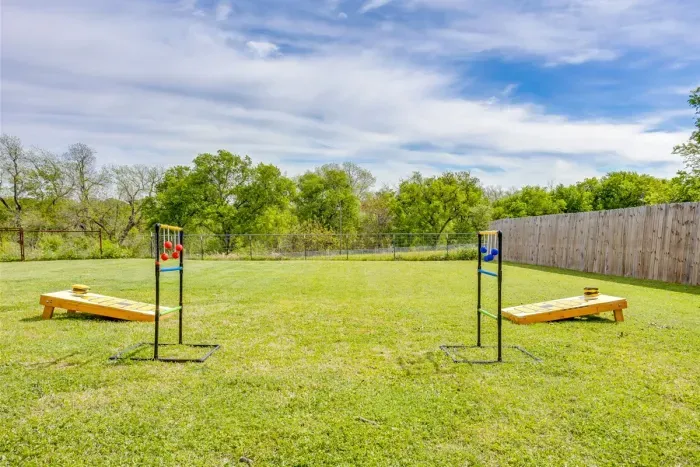 Huge fenced backyard with cornhole, open green space, and room to spread out — great for games, kids, and pets.