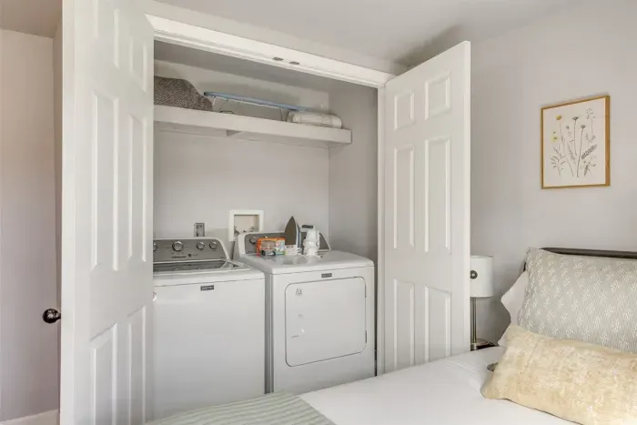 In-unit washer and dryer tucked right inside the bedroom closet — everything you need for longer stays without leaving home.