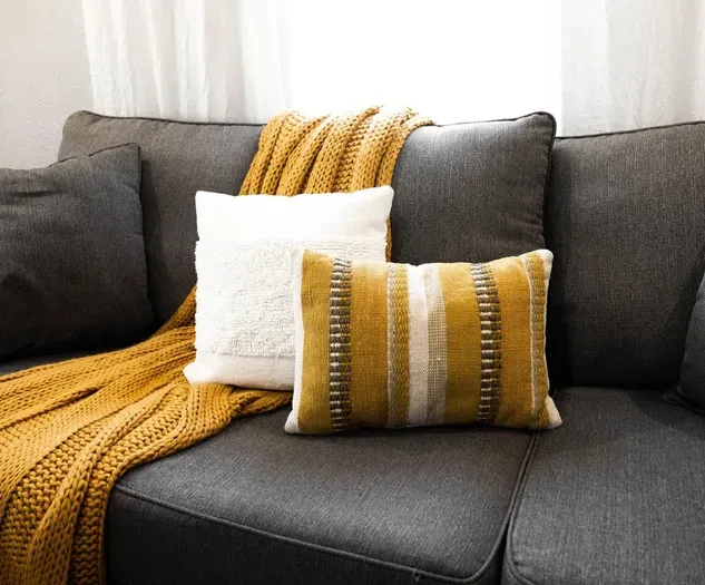 Attention to detail shines in this stylish living room, combining comfort and elegance with modern accents and plush pillows.