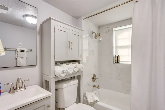 Clean, well-stocked bathroom with vanity, storage cabinet, fresh towels, and all the essentials provided for your stay.