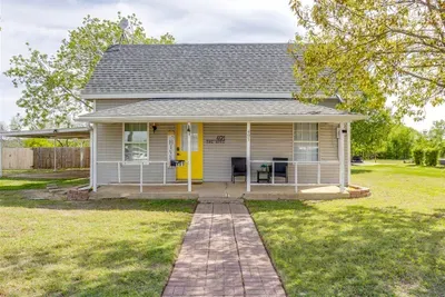 The Hive from the outside — covered front porch, yellow accents, and a brick walkway leading right to your door.