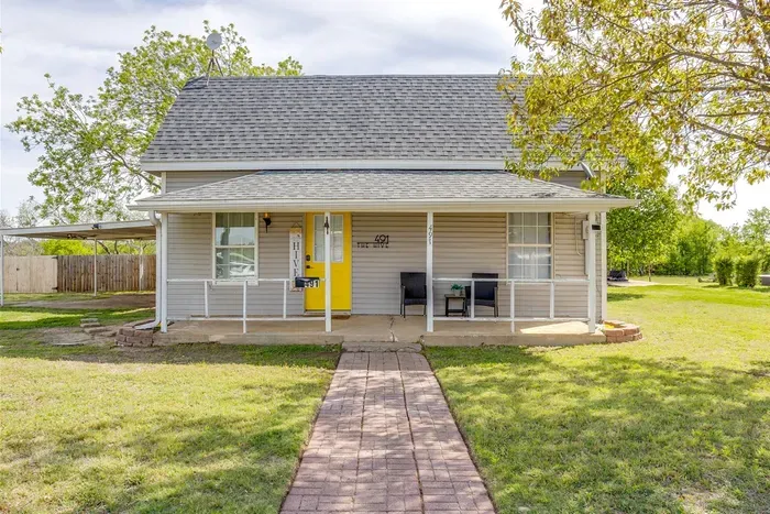 The Hive from the outside — covered front porch, yellow accents, and a brick walkway leading right to your door.