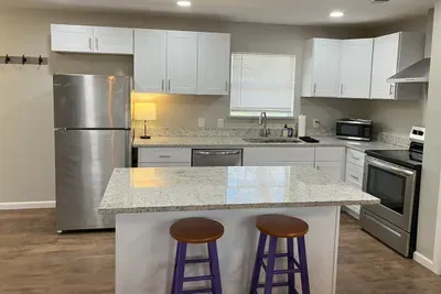 Modern kitchen with a large island and bar seating, ideal for gathering and enjoying meals during your stay in Stephenville