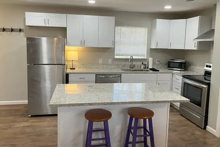 Modern kitchen with a large island and bar seating, ideal for gathering and enjoying meals during your stay in Stephenville